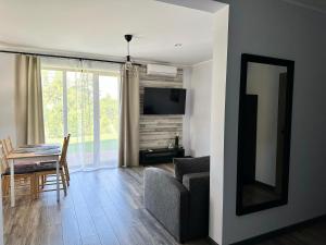 a living room with a couch and a table and a television at Apartamenti Zaķi in Saulkrasti