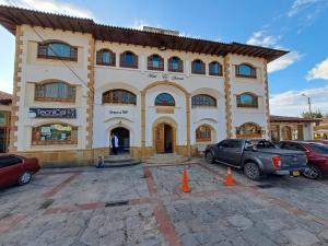 瓜塔维塔Hotel El Dorado Guatavita的一座大楼，前面停满了汽车