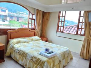 瓜塔维塔Hotel El Dorado Guatavita的一间带床和大窗户的卧室