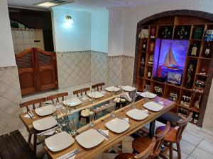 瓜塔维塔Hotel El Dorado Guatavita的餐厅里一张长桌,配有白色的桌椅 更多21张照片