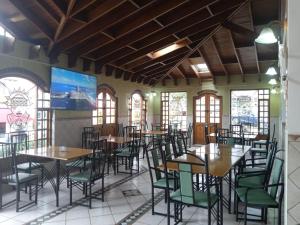 瓜塔维塔Hotel El Dorado Guatavita的有桌椅和窗户的餐厅