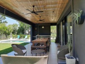 a patio with a wooden ceiling and a table and chairs at Casa en El lucero, Pilar in Manuel Alberti