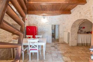 a dining room with a white table and chairs at Trullo Matilde in Martina Franca