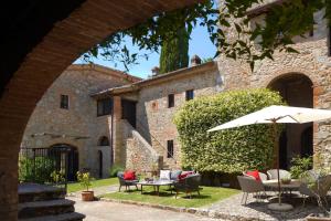 Torre Palazzone في سوفيتشيلي: فناء مع طاولة وكراسي ومظلة