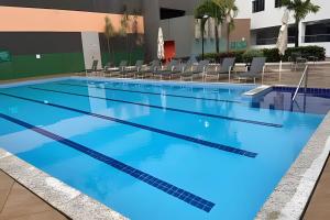 an empty swimming pool with blue water at Apto em Rio Quente com ampla área de lazer e linda vista in Rio Quente +41 photos