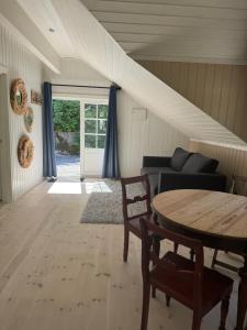 a living room with a table and a couch at Cosy cabin in Risør in Risør +3 photos