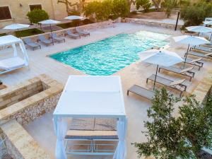 an overhead view of a pool with chairs and umbrellas at Masseria Pozzelle in Otranto