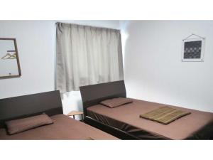 una camera da letto con due letti e una finestra di AMA TERRACE - Vacation STAY 31145v ad Amami Altre 52 foto