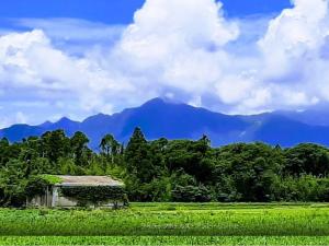 an old house in a field with mountains in the background at Lilac Hotels and Resorts - Vacation STAY 39764v in Kanoya