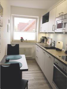 een kleine keuken met een tafel en een raam bij Fewo-Warns-Bad-Zwischenahn in Bad Zwischenahn