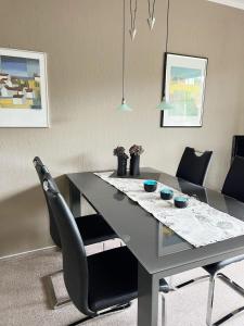 een eettafel met 2 stoelen en een eetkamer bij Fewo-Warns-Bad-Zwischenahn in Bad Zwischenahn