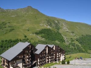 a building with a mountain in the background at Charmant studio cabine aux Ménuires, pied des pistes, balcon, animaux permis, accès télébenne gratuit - FR-1-452-43 in Les Menuires