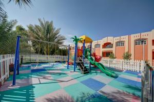 einen Spielplatz vor einem Gebäude mit Rutsche in der Unterkunft Asfar Resorts Al Ain in al-Ain