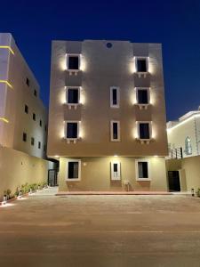 een groot wit gebouw met ramen aan de zijkant bij A Chill Modern Apartment in Riyad