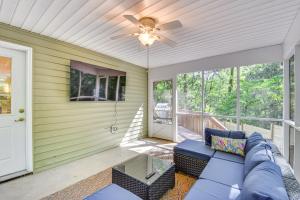 a porch with a blue couch and a ceiling fan at Anderson Retreat Private Hot Tub and Kayaks! in Anderson
