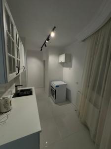 a white kitchen with a sink and a stove at Art Apartment 2 in Prishtinë