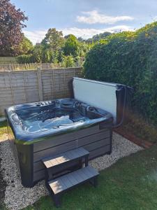 a jacuzzi tub sitting in a yard at King Arthur's Rest House, Hot Tub & Garden Sleeps 10 in South Cadbury