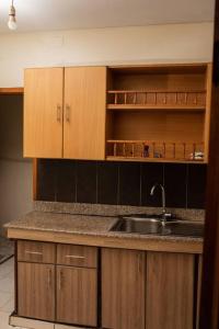 a kitchen with a sink and wooden cabinets at Blissful Homes in Kampala