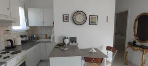 a kitchen with a counter and a clock on the wall at White Beach Appartment in Yerakiní +9 photos