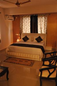 a bedroom with a large bed and a window at Hotel Dewa Goa in Dabolim