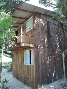 - un petit bâtiment en bois avec deux fenêtres dans l'établissement Cantinho da Luz - Ilha do Mel - Paraná - Nova Brasília - Praia Grande - Canto da Vó, à Paranaguá