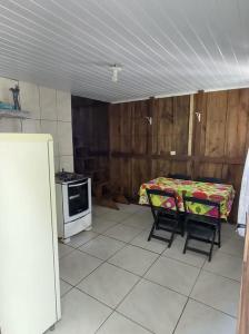 une cuisine avec une table et deux chaises et un lit dans l'établissement Cantinho da Luz - Ilha do Mel - Paraná - Nova Brasília - Praia Grande - Canto da Vó, à Paranaguá