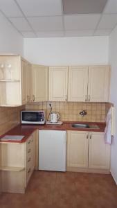 a kitchen with white cabinets and a sink and a microwave at Penzion Mika in Jindřichŭv Hradec