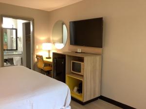 a hotel room with a bed and a television at Days Inn by Wyndham Kingdom City in Kingdom City