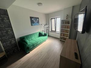 un salon avec un canapé vert et une table dans l'établissement Solaria Top Apartment, à Galaţi
