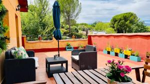 a patio with chairs and an umbrella and a table at Hotel Rural El Arca de Noé in El Tiemblo