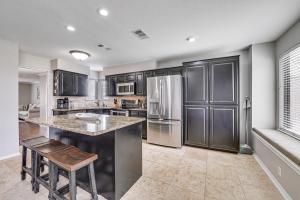 a kitchen with stainless steel appliances and a large island at 10 Mi to Lake Lewisville Carrollton Home with Pool in Carrollton