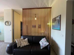 a living room with a black leather couch in a room at Suite Laghetto EUR in Rome
