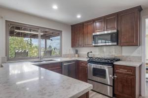 a kitchen with wooden cabinets and a stove top oven at Elm Mountain View Fire pit, quiet and more in Los Angeles