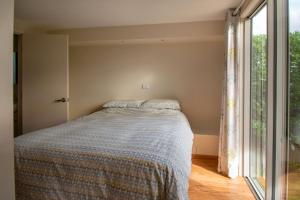 a bedroom with a bed and a large window at Estuary Escape Mapua in Mapua