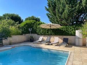 a swimming pool with two chairs and an umbrella at La Serva in Les Lèches