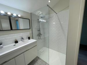 a white bathroom with a sink and a shower at La Serva in Les Lèches +81 photos