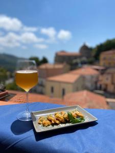 un piatto di cibo e un bicchiere di vino su un tavolo di La terrazza nel borgo a Tortora