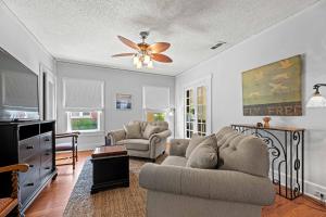 un soggiorno con un divano e un ventilatore a soffitto di Mistletoe Heights Bungalow a Fort Worth