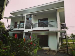 Casa blanca con balcones y plantas en Scala Inn, en Muelle