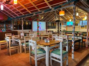 a dining room with wooden tables and chairs at Art Resort Goa in Palolem