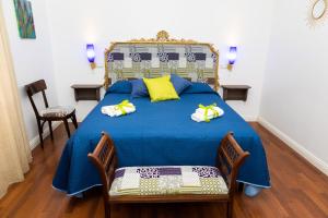 una camera da letto con letto blu e cuscini gialli di Ai Mercati di Palermo a Palermo