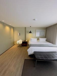 a hotel room with two beds and a desk at The Grace Hotel in Bogotá