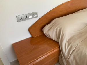 a bed with a wooden headboard and a wooden night stand at Cortijo LOS MIRADORES in Vélez Blanco