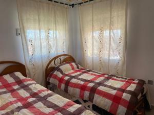 two twin beds in a room with curtains at Cortijo LOS MIRADORES in Vélez Blanco
