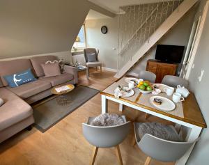 a living room with a table and a couch at Ferienwohnung Annika 2 in Tinnum