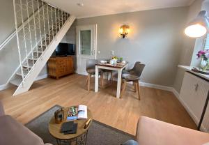 a living room with a table and a staircase at Ferienwohnung Annika 2 in Tinnum +20 photos