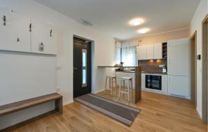 a kitchen with white cabinets and a wooden floor at Lovely Home In Margecan With Wifi in Gačice