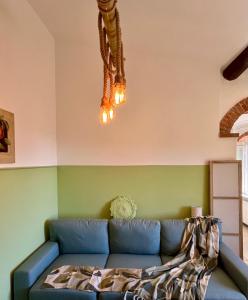 a living room with a blue couch and a chandelier at Casa Olive 53 Mare in La Spezia