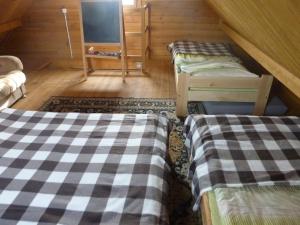a attic room with two beds and a tv at Domek Nad Jeziorem in Sierakowice