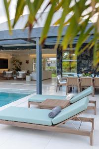 an outdoor pool with a chaise lounge next to a swimming pool at Hill Rock villas - Blue Silver in Petit-Bourg
